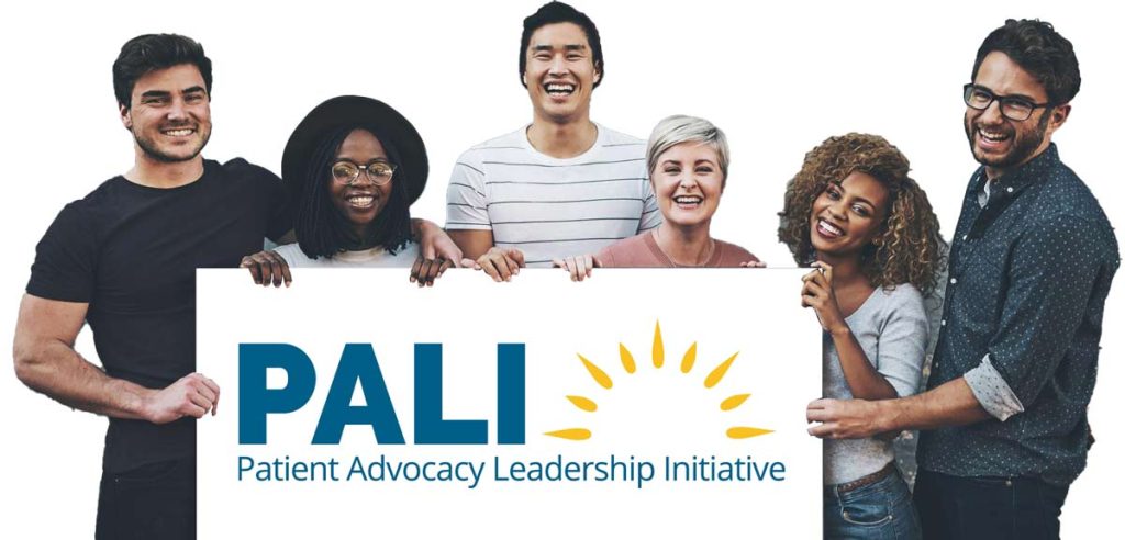 Six smiling people of diverse backgrounds stand together holding a large sign that reads "PALI Patient Advocacy Leadership Initiative" with a yellow sun graphic.
